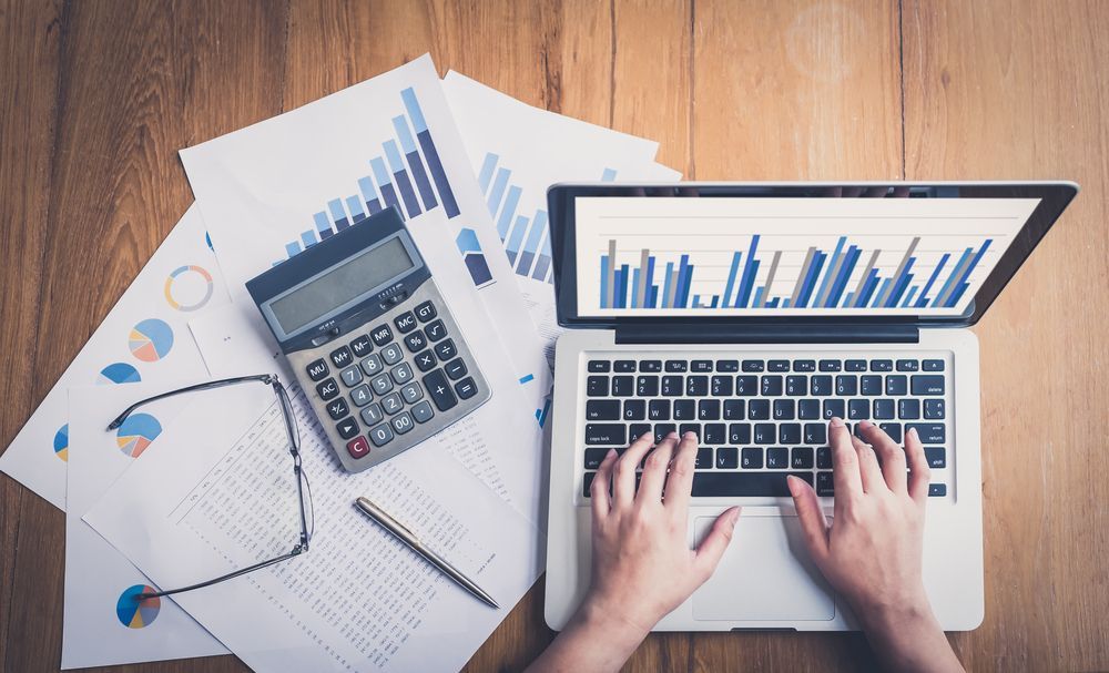 Hands Typing on Laptop Beside Calculator — Emmel Finance in Townsville, QLD