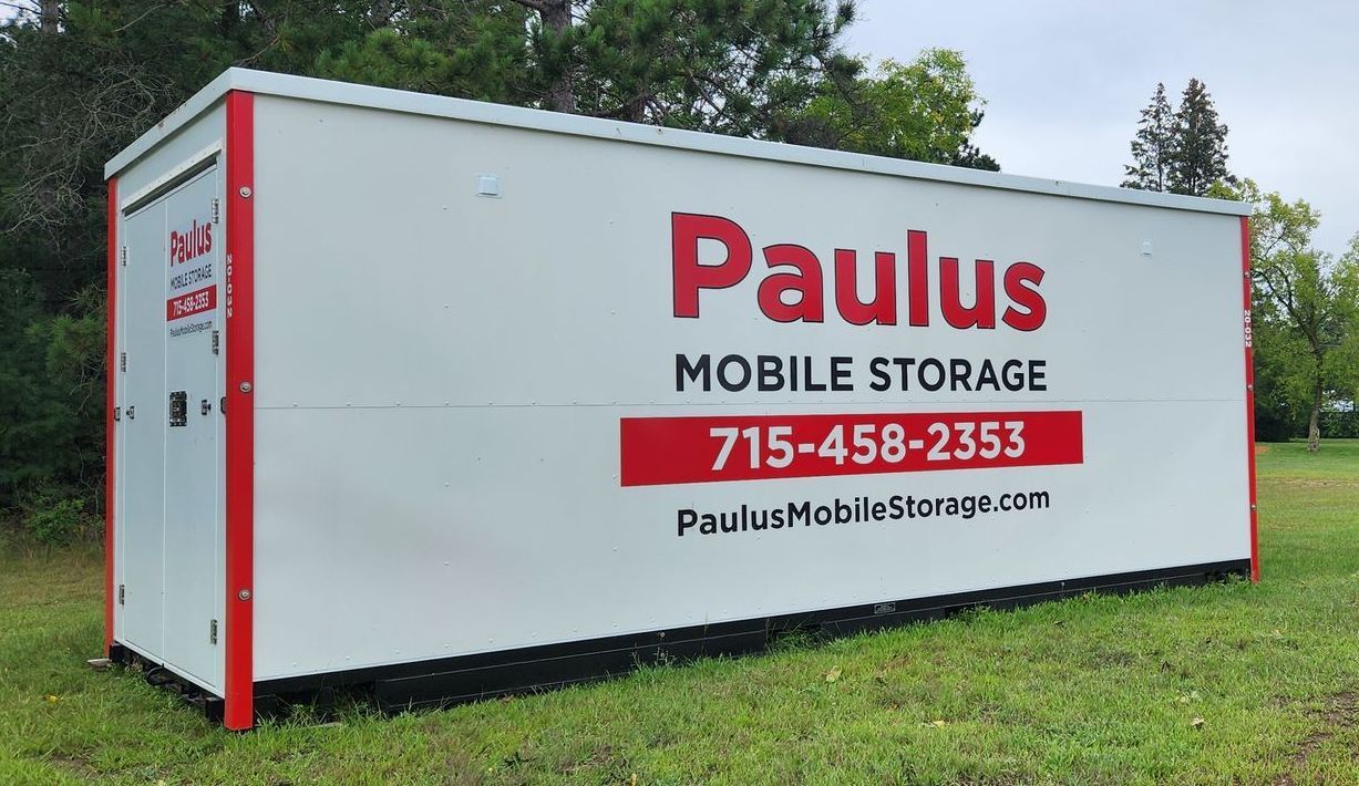 A woman is standing in front of a semi truck with the door open.