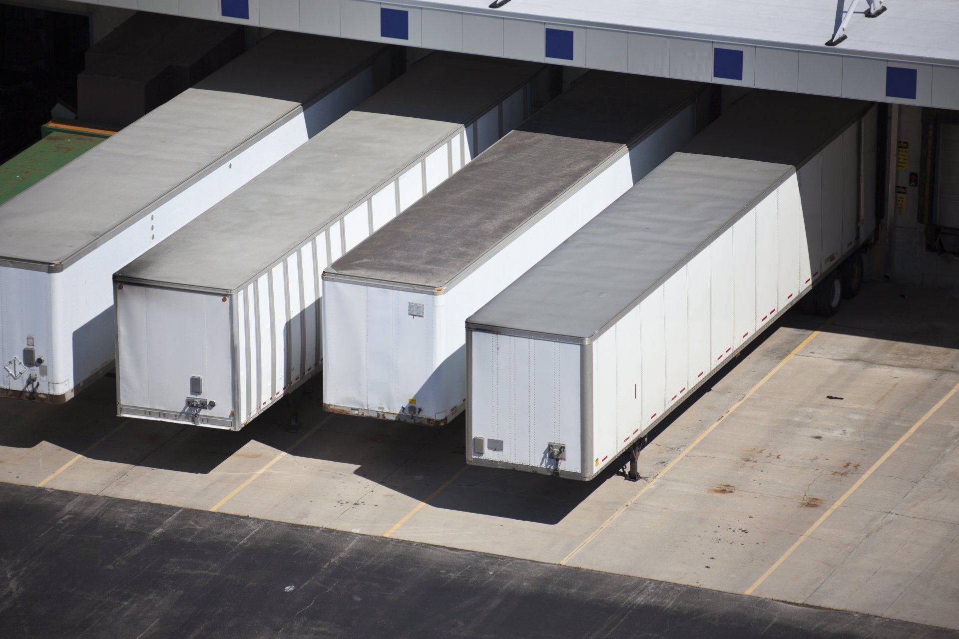 A row of semi trucks are parked in a parking lot