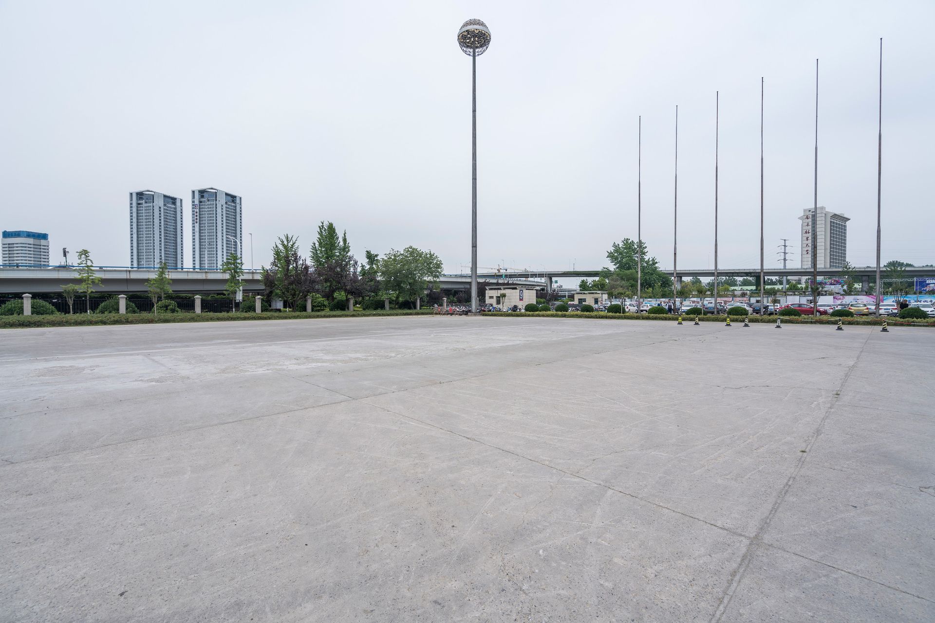 An empty parking lot with a highway in the background.