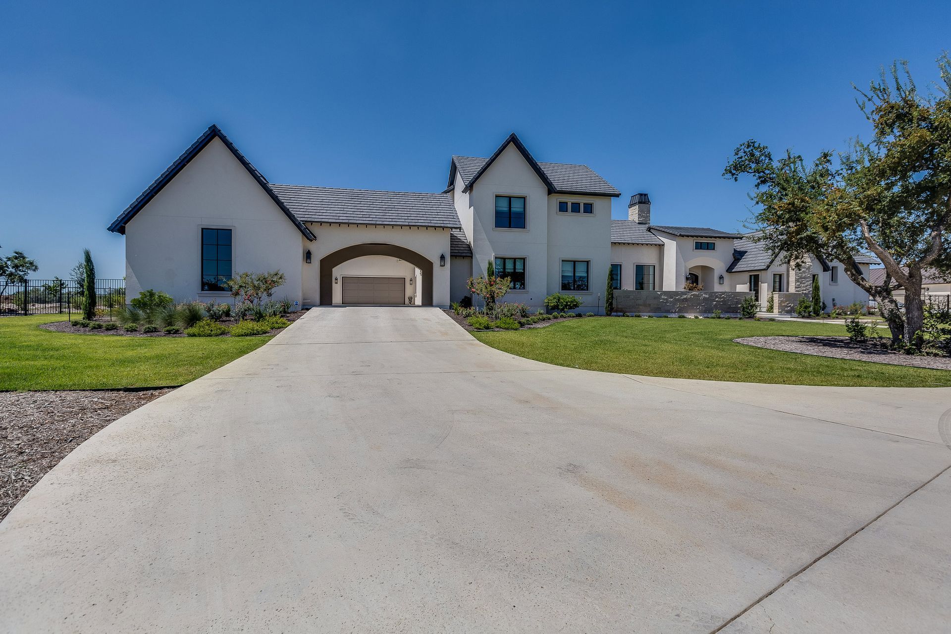 A large white house with a driveway leading to it.