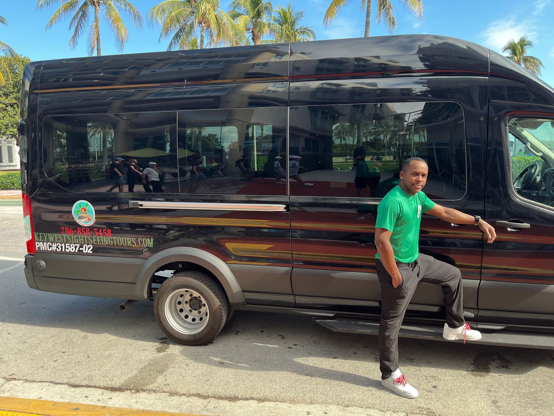Tour guide with green uniform in Bayside Marketplace waiting to start the Miami Sightseeing Bus tour with hop on and hop off 
