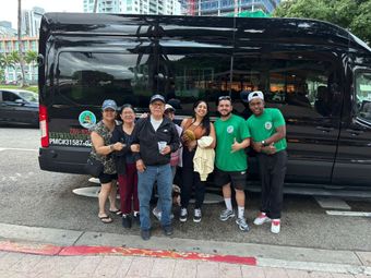 Guest taking a photo with the tour guide and driver in front of the Hop on Hop off Miami tour bus at Downtown Miami’s Bayside Marketplace.
