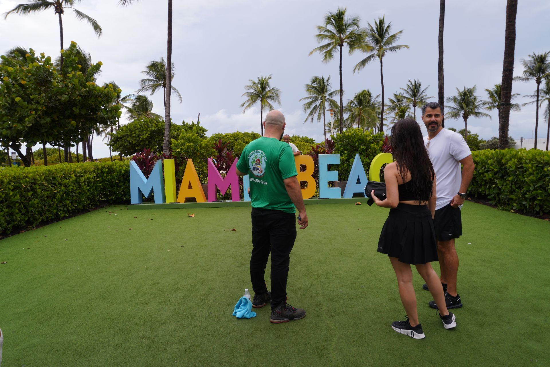 Miami Bus Tour with passengers at the Miami Beach sign with tour guide