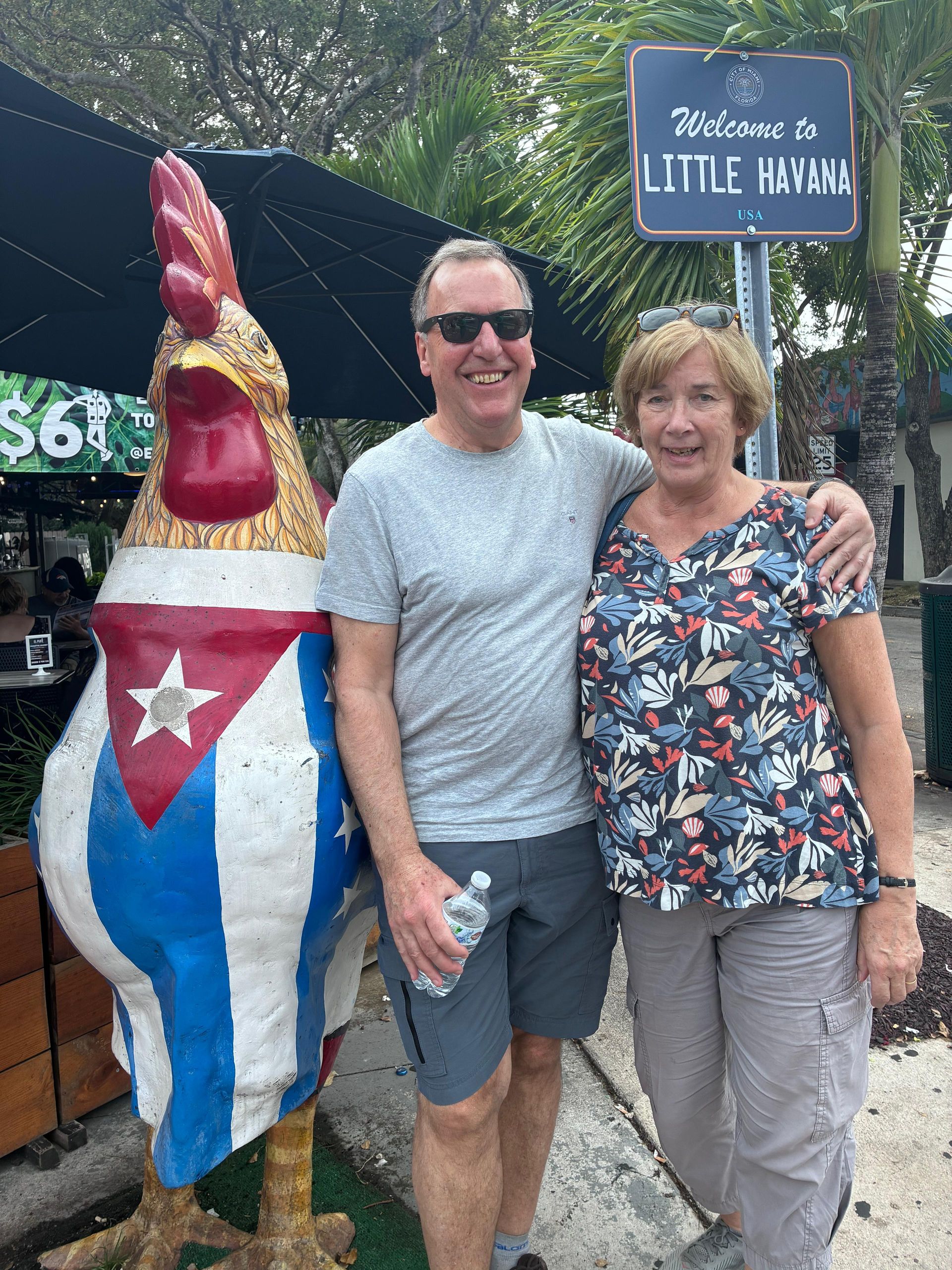 Guests posing with the iconic rooster statue at Little Havana during a Hop On Hop Off Miami bus tour stop.
