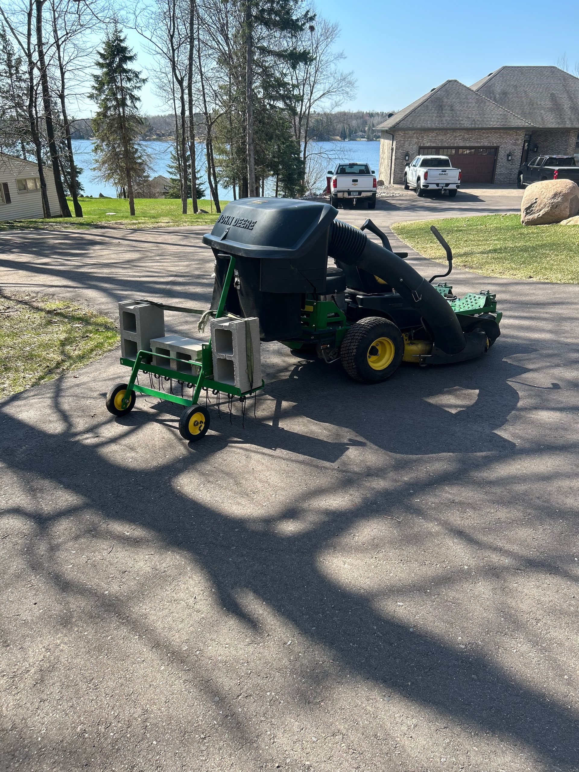 A john deere lawn mower is parked on the side of the road.