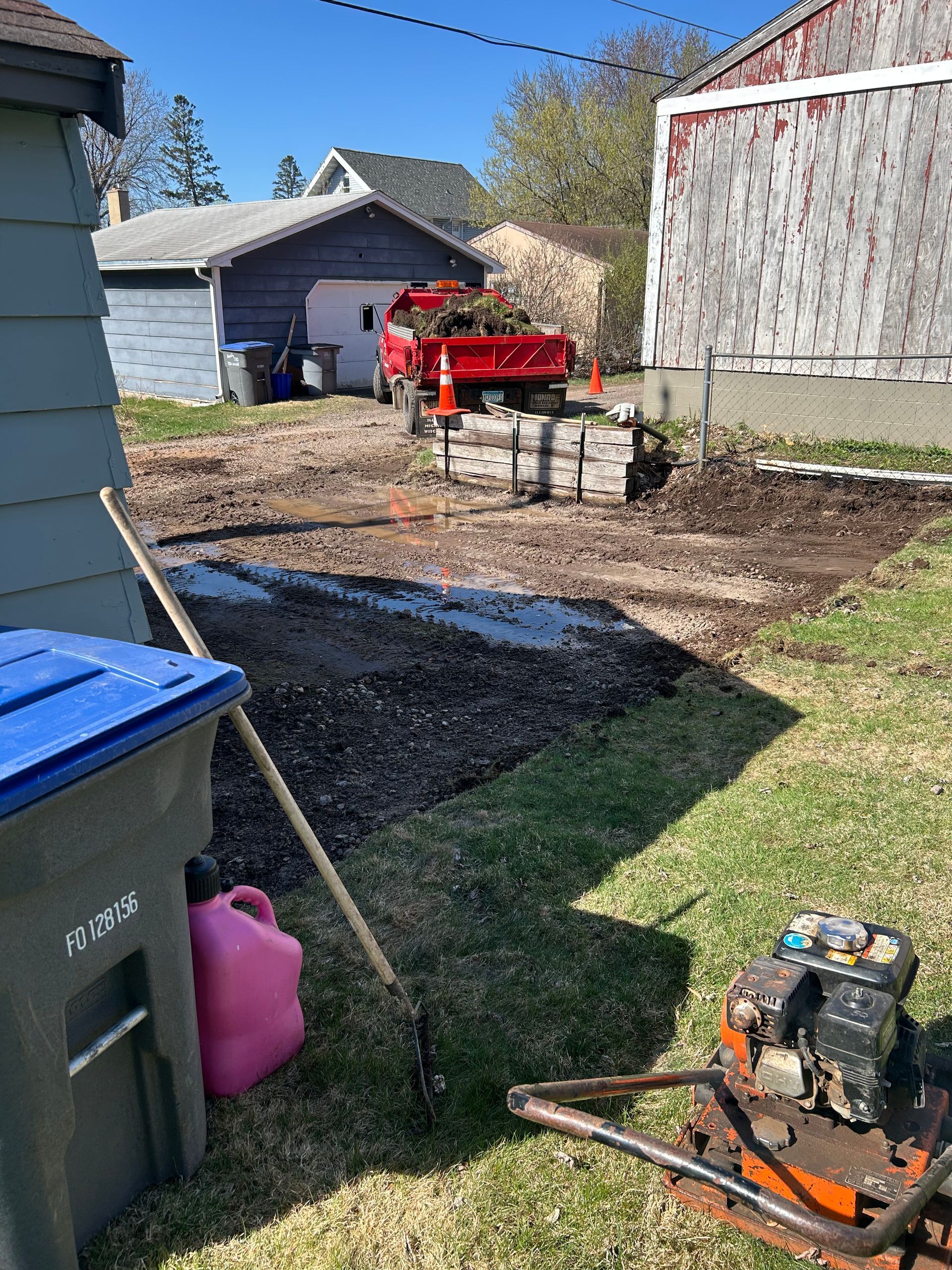 A red truck is parked in the backyard of a house.