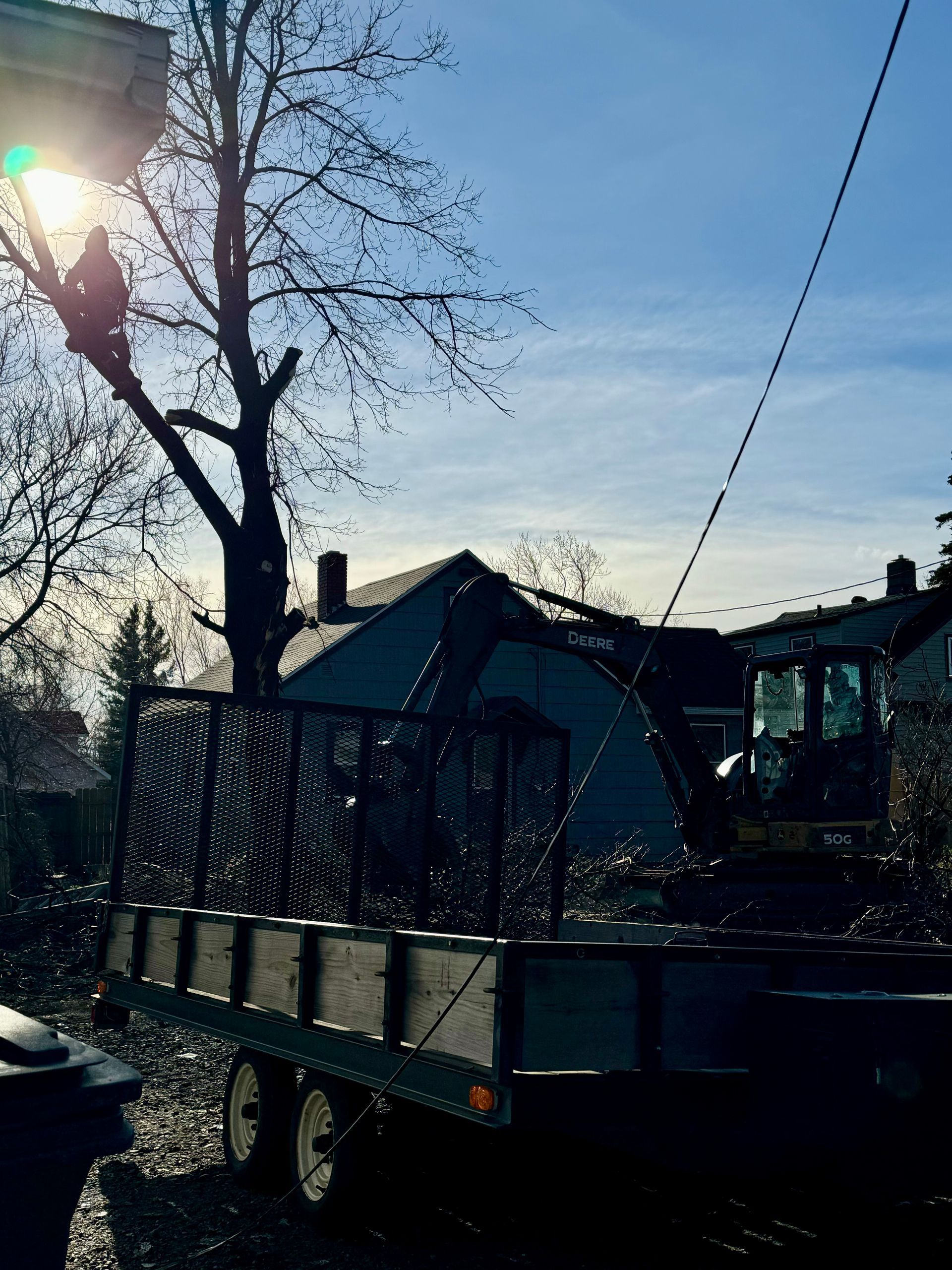 A truck with a trailer attached to it is parked in front of a house.