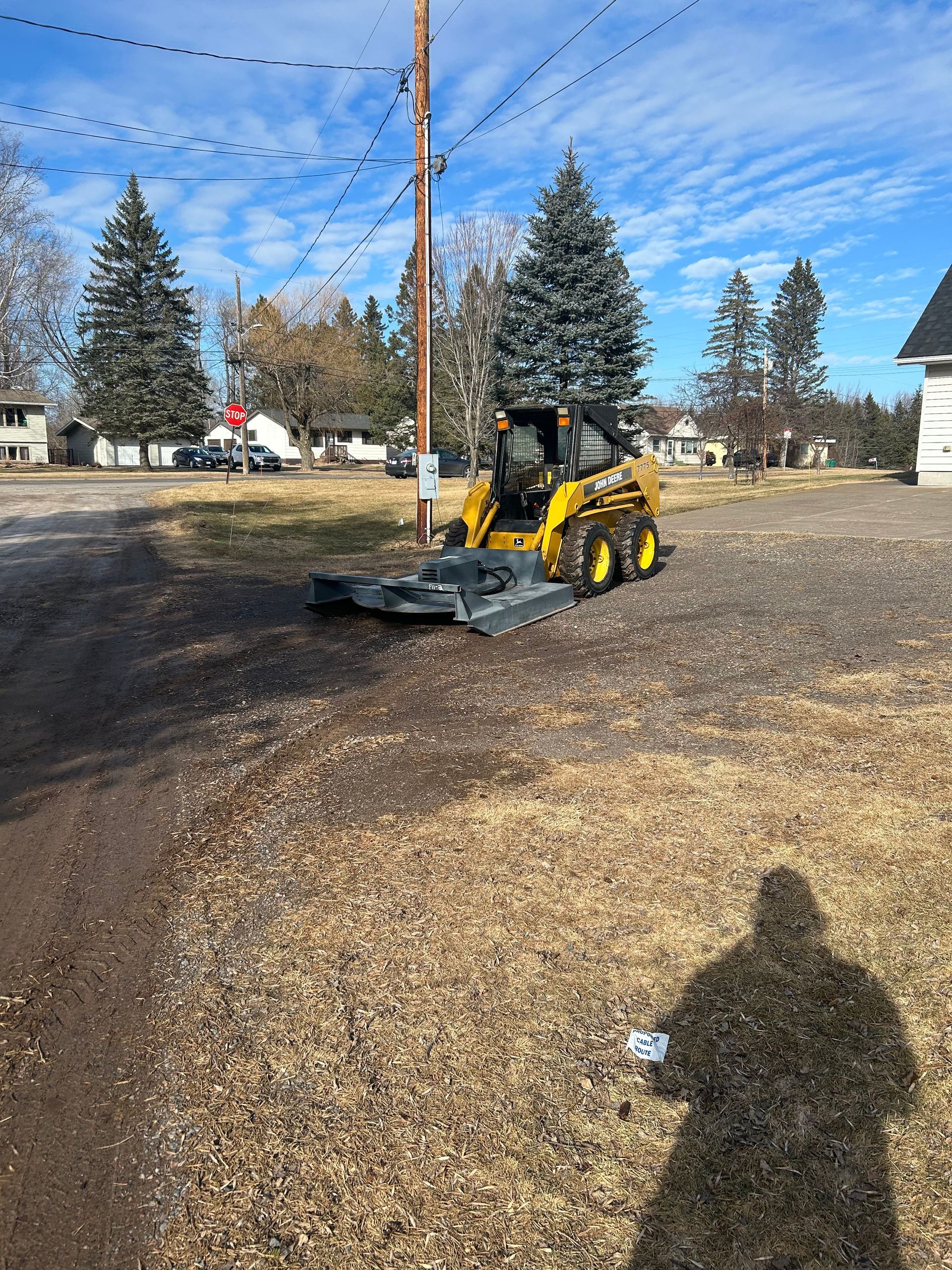 A yellow tractor is parked on the side of the road