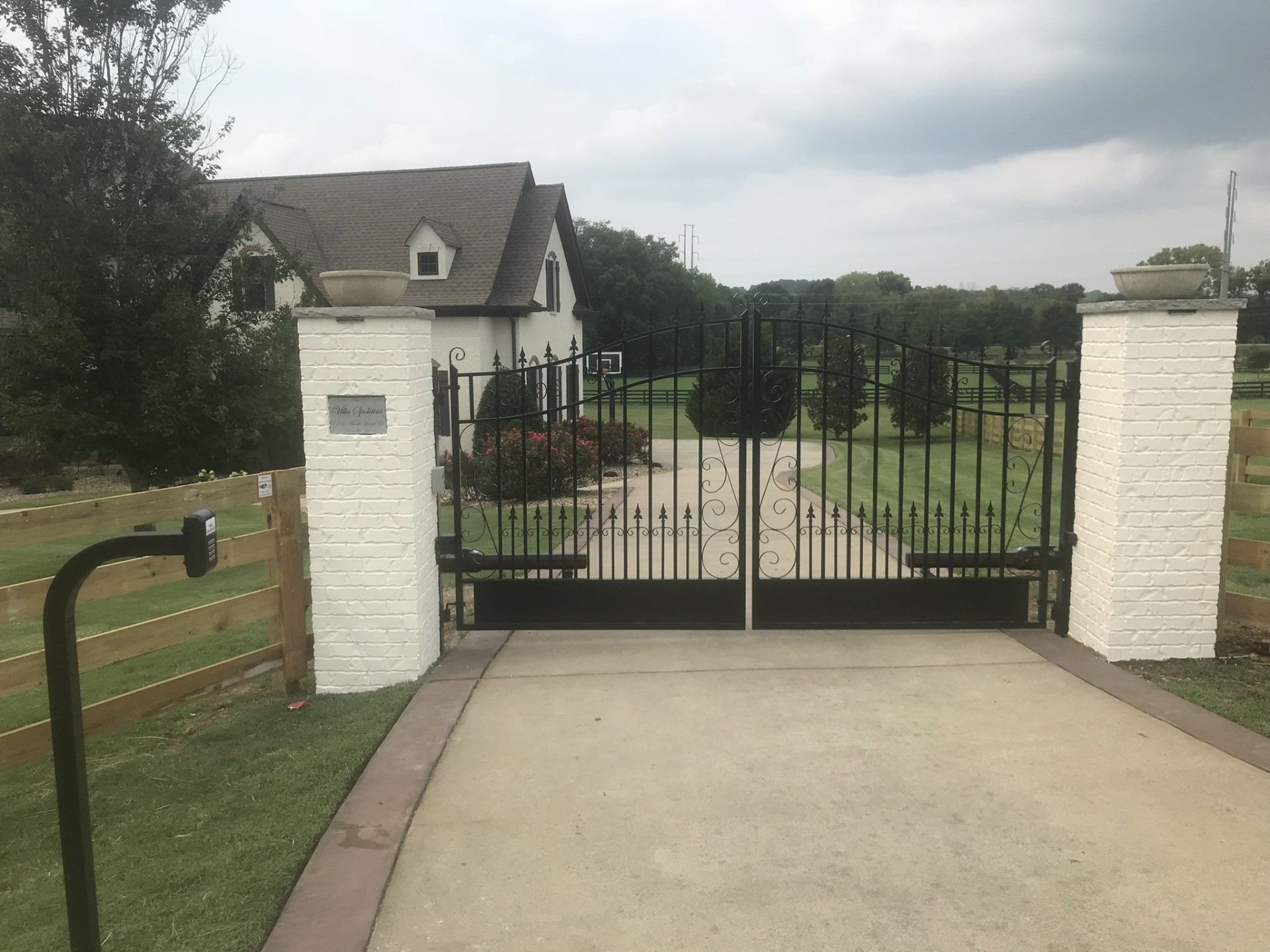 a white house with a black gate in front of it