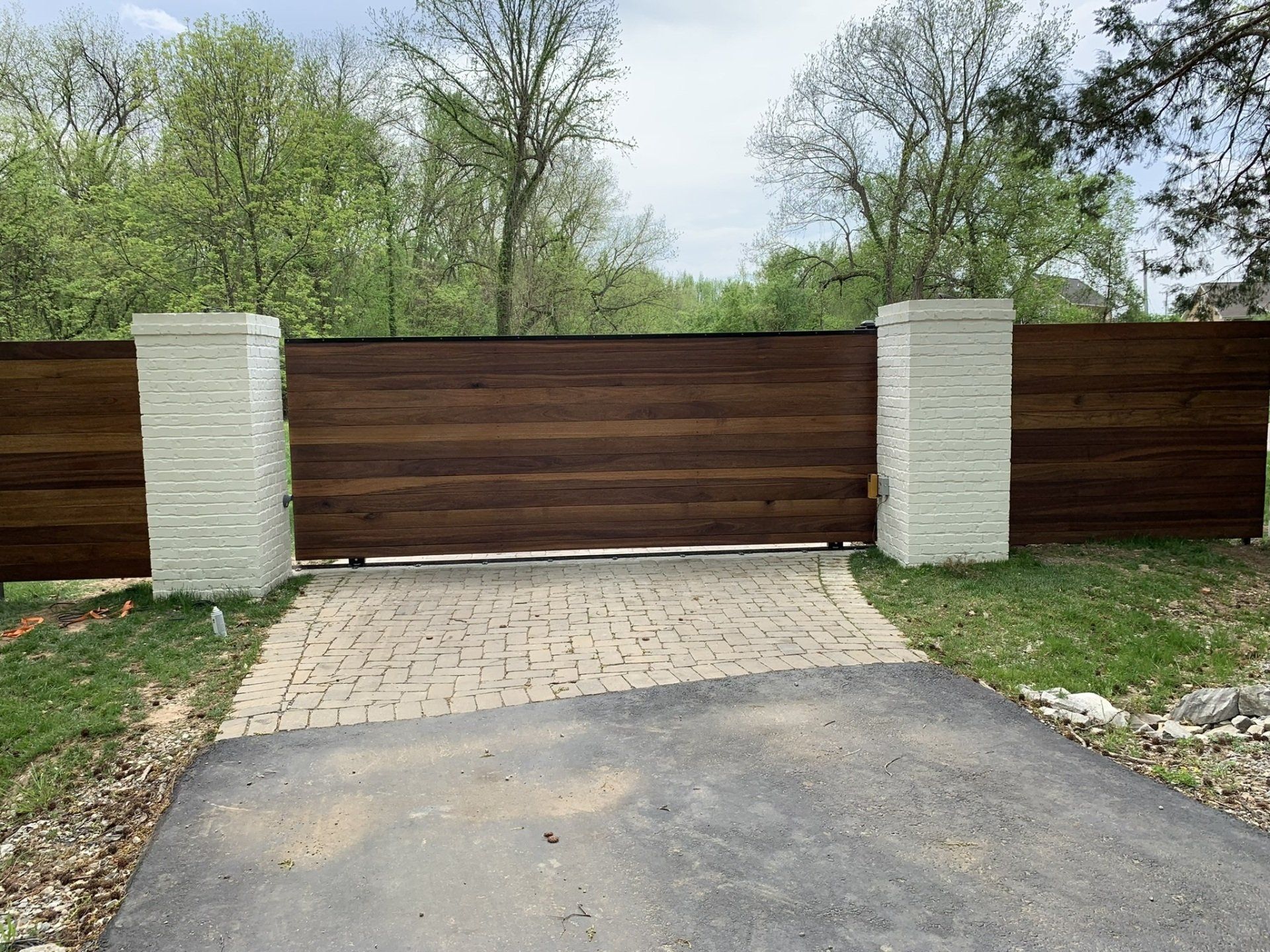 a wooden gate is sitting in the middle of a driveway .