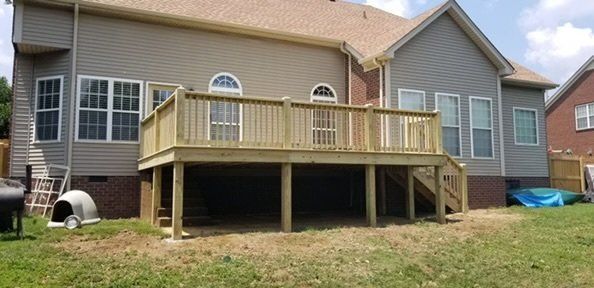 a large house with a wooden deck in front of it .