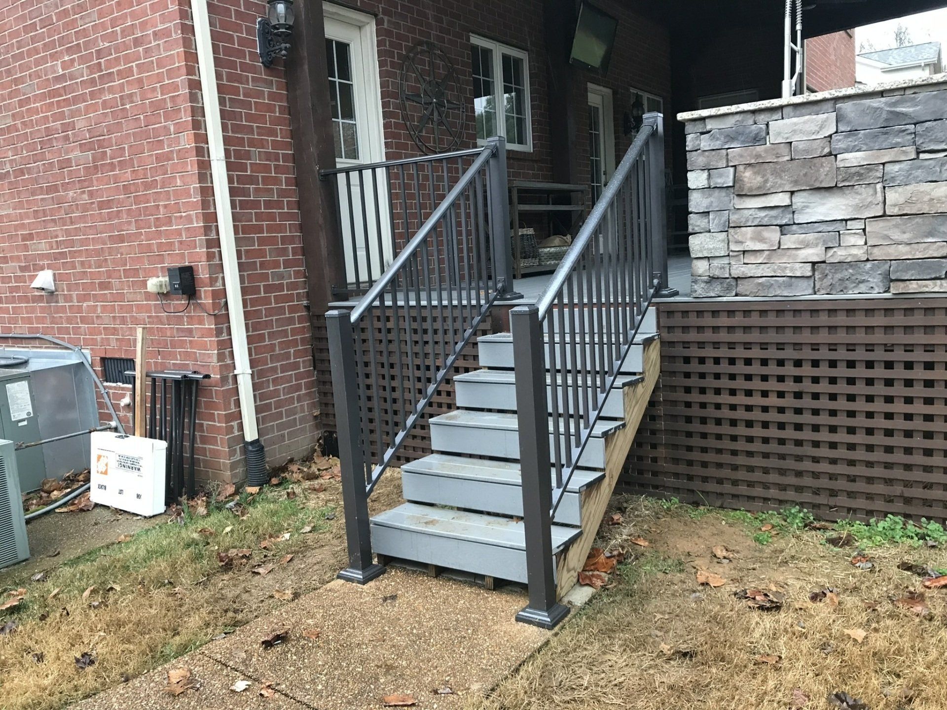 a set of stairs leading up to a brick house with a metal railing .