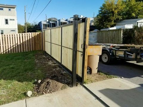 a wooden fence is being built in a driveway next to a truck .