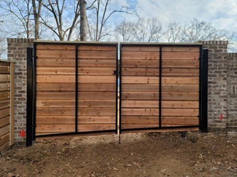 a wooden gate is attached to a brick wall .