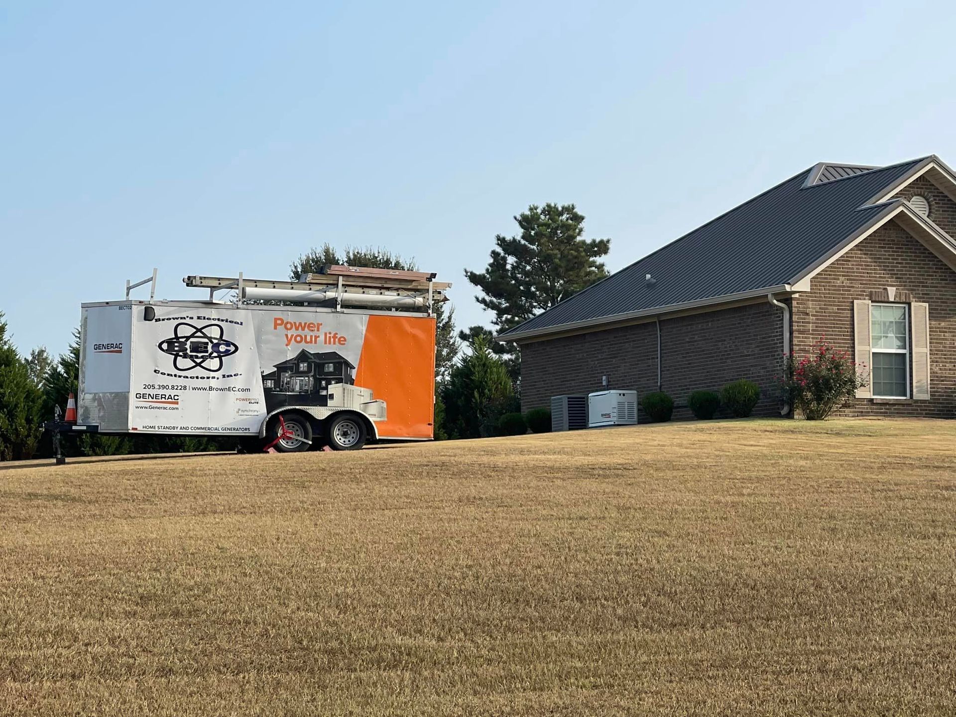 An orange and white trailer is parked in front of a house.