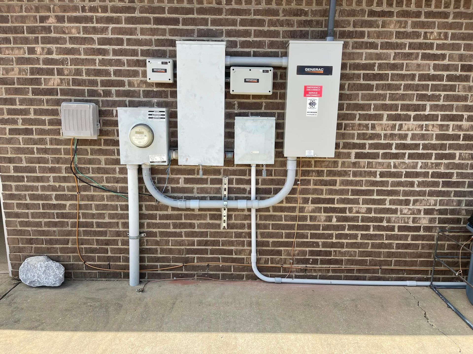 A brick wall with electrical boxes attached to it