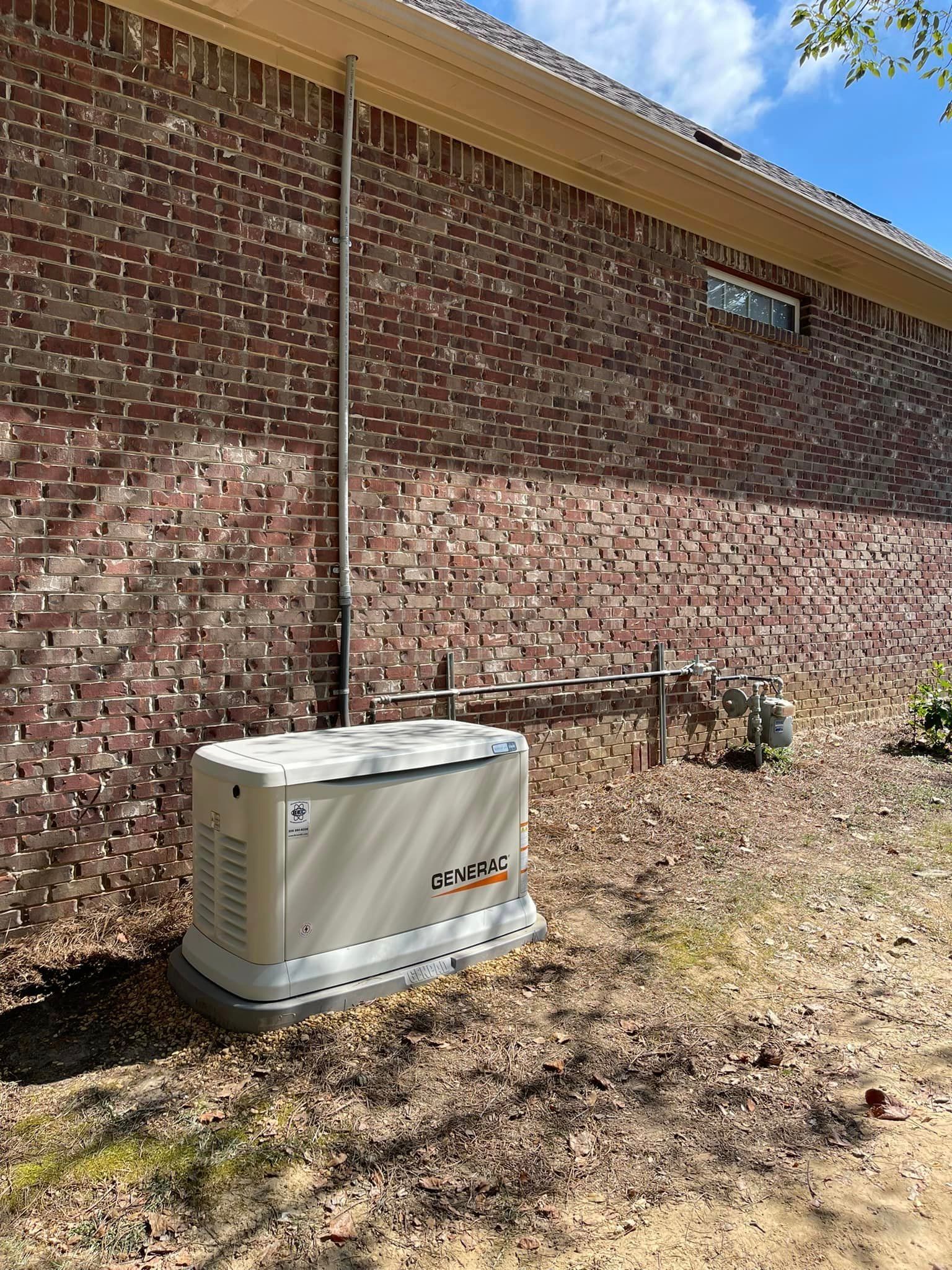 A generator is sitting in the backyard of a brick house.