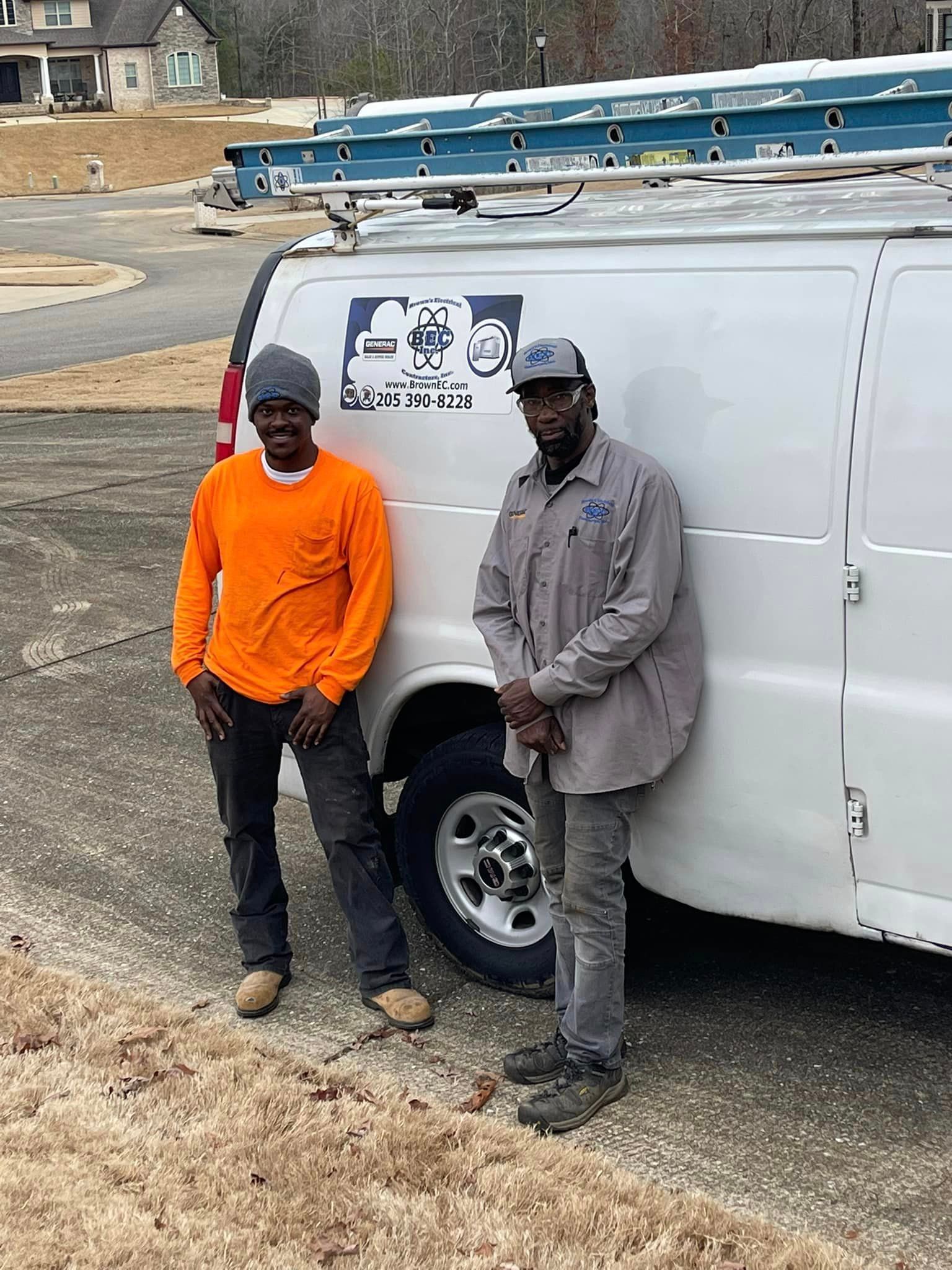 Two men are standing next to a white van.