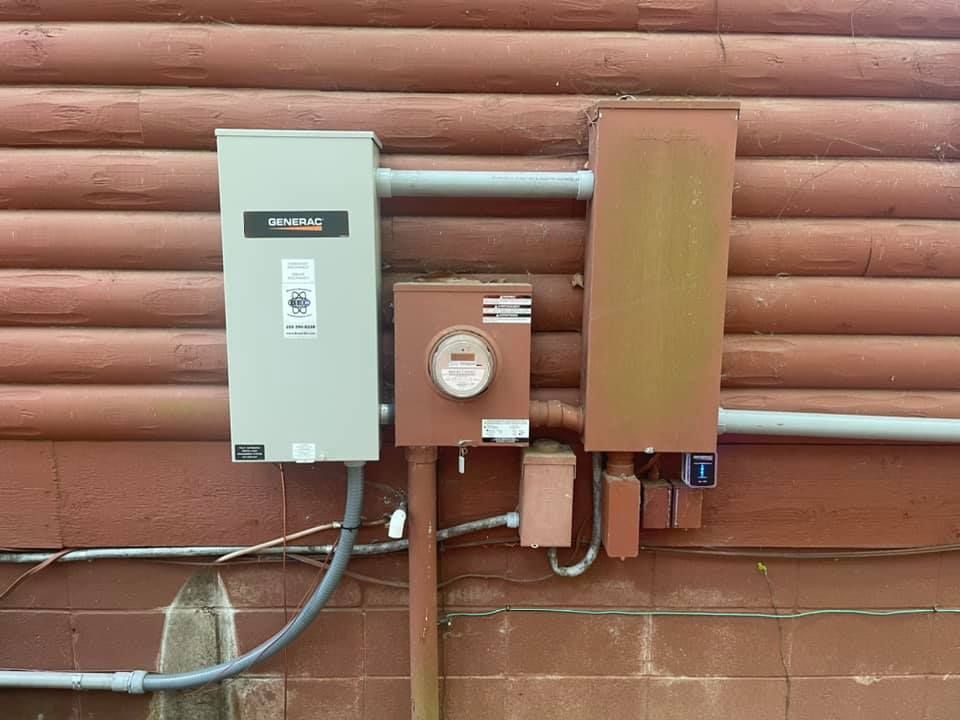 A electrical box is attached to the side of a wooden building.