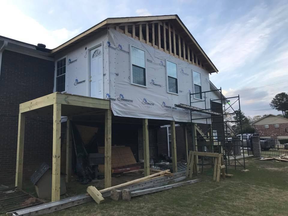 A house is being remodeled with a porch and scaffolding.