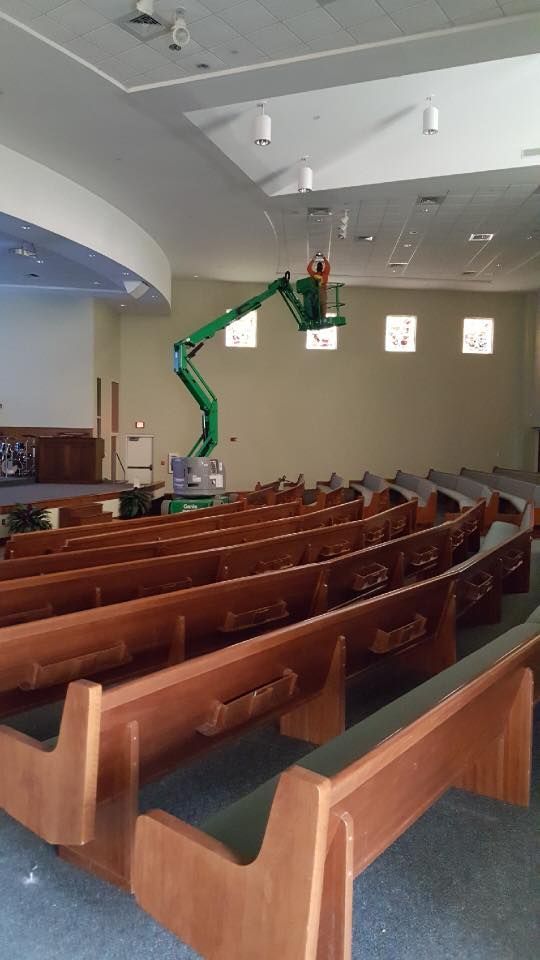 A man is working on the ceiling of a church.