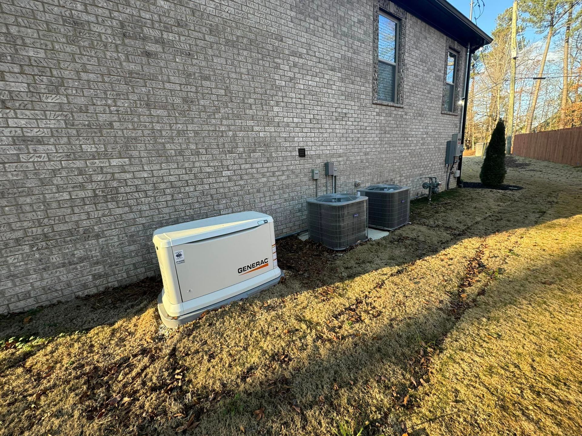 A brick house with a generator on the side of it.