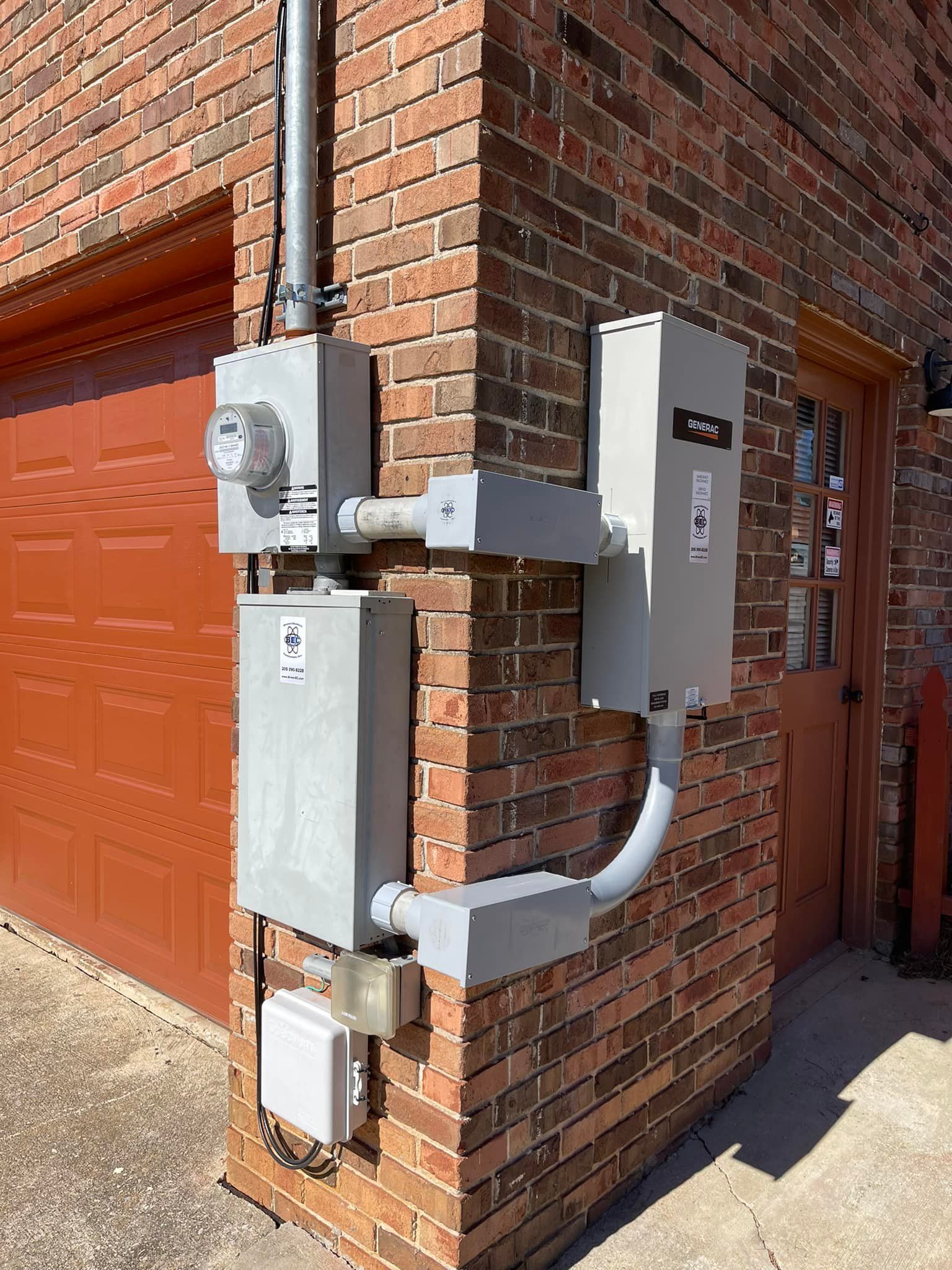 A brick wall with a electrical box attached to it.