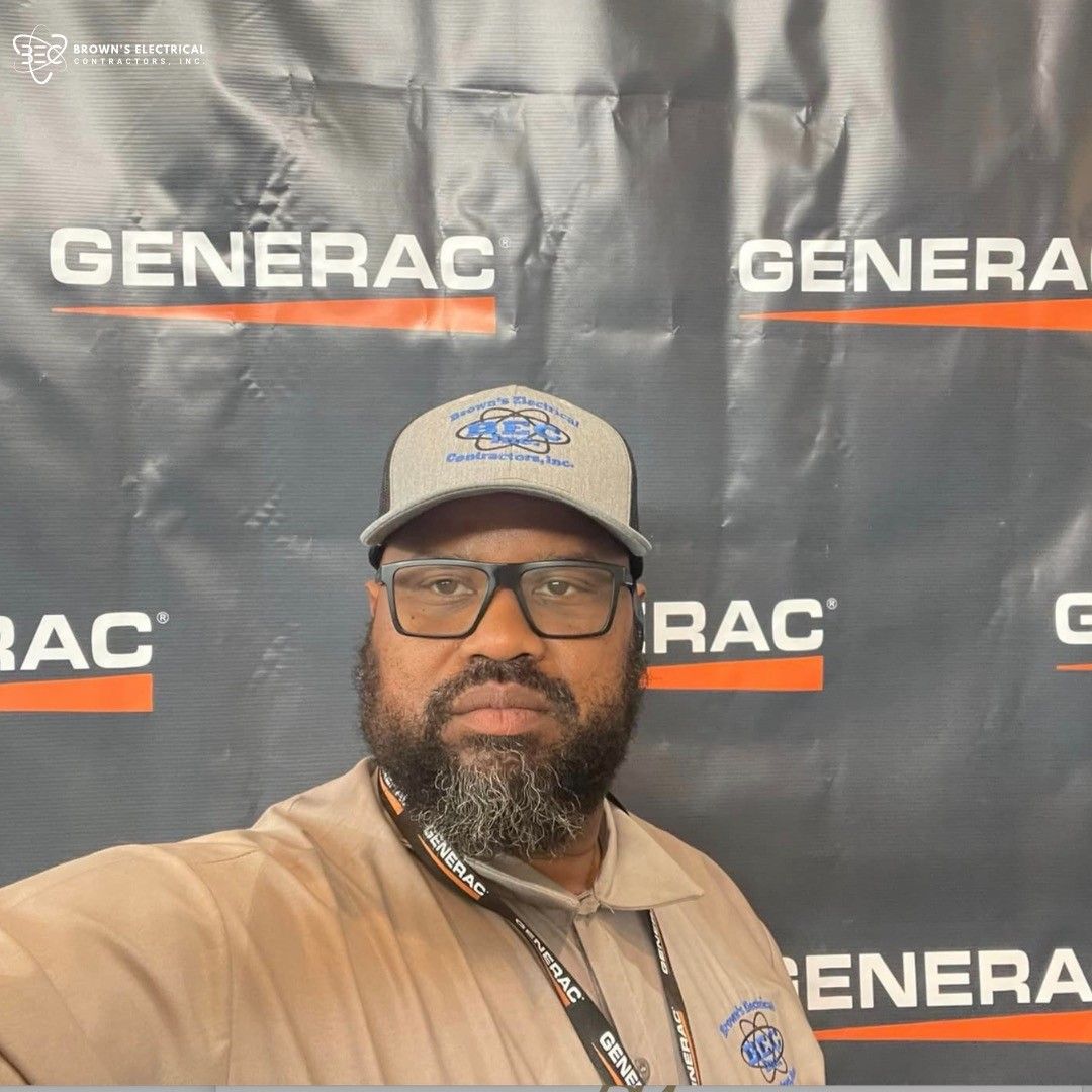 A man taking a selfie in front of a banner that says generac