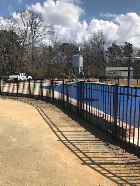 A fence surrounds with trees in the background