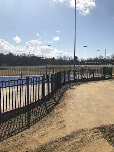 A fence surrounds a baseball field on a sunny day