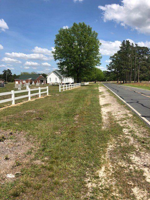 A white fence along the side of a road