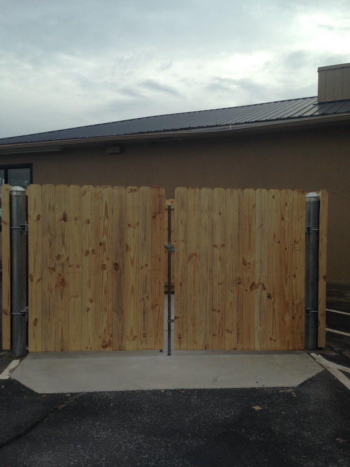 A wooden fence is in front of a building