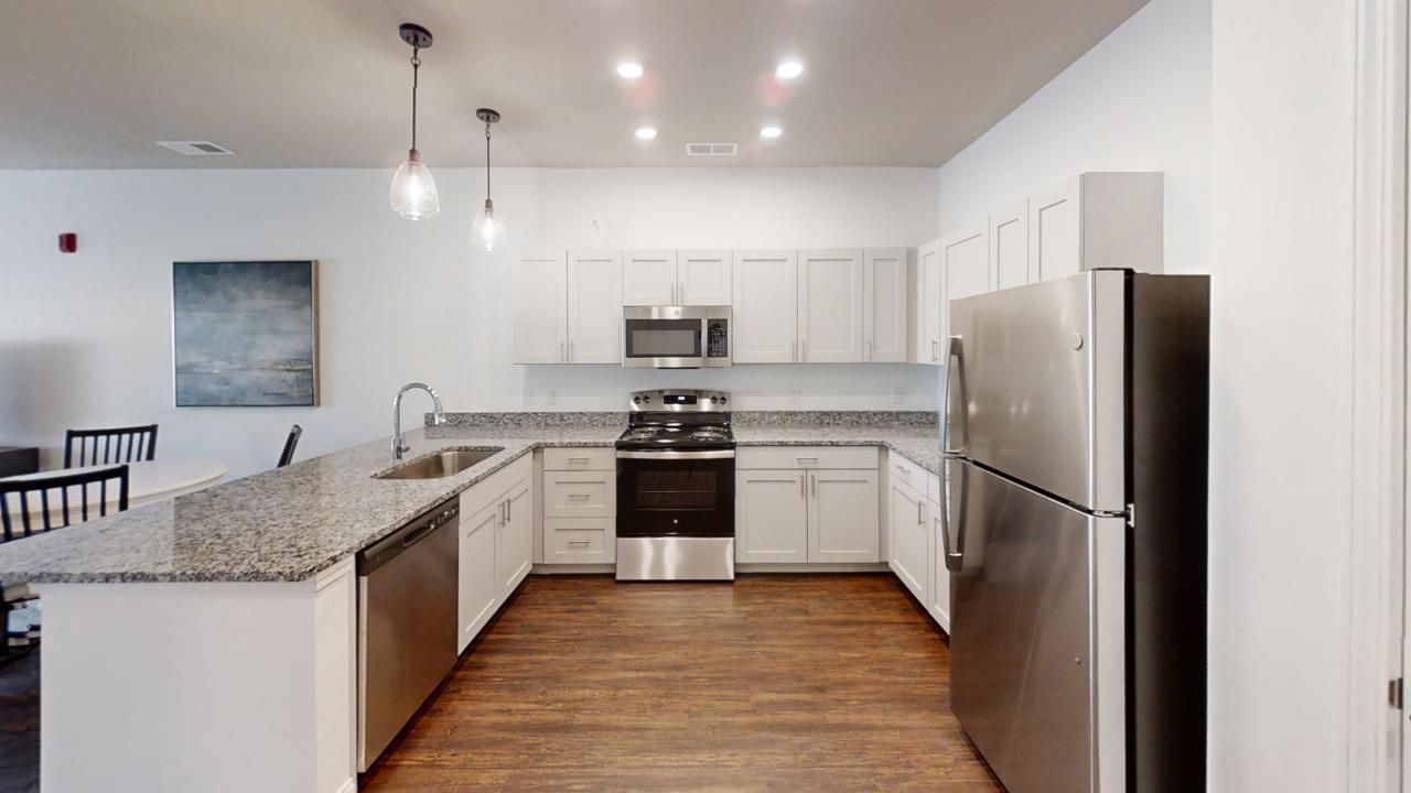 A kitchen with stainless steel appliances and granite counter tops.