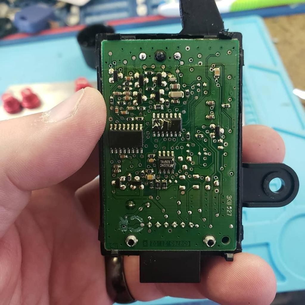 A close up of a person holding a motherboard in their hand