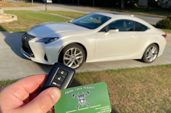White car on the background, car keys and Viking Lock Service business card