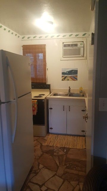 A kitchen with a refrigerator , stove , sink and microwave.