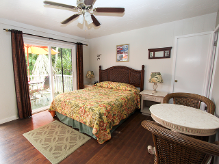 A bedroom with a king size bed and a ceiling fan