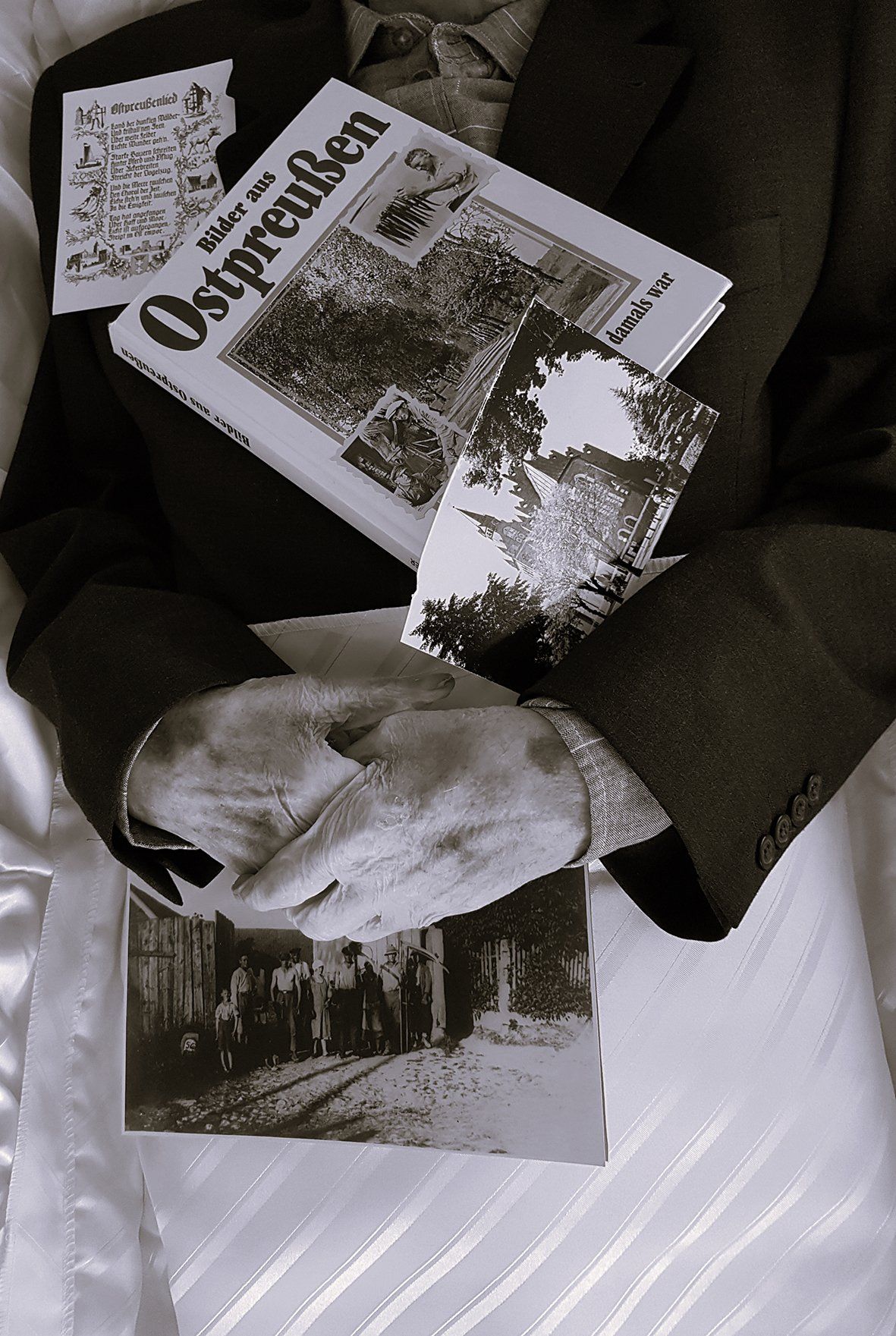 Ein Mann im Anzug hält ein Buch mit dem Titel „Ostpreußen“ in der Hand.