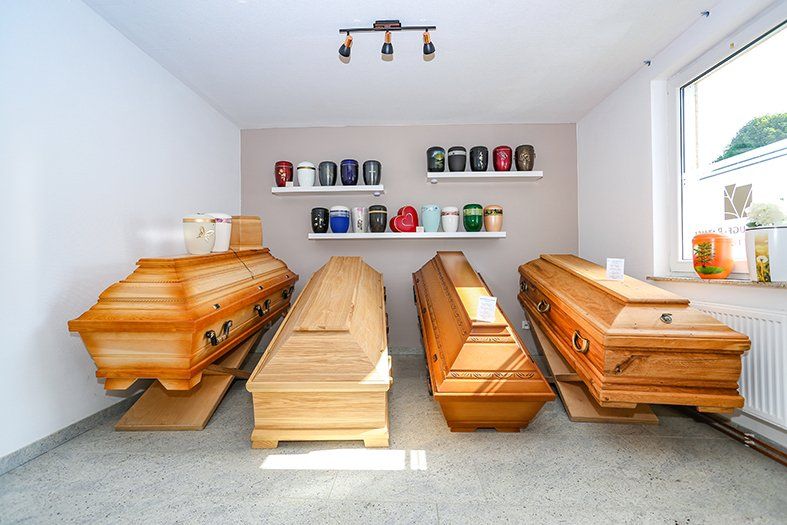 Drei Holzsärge sind in einem Raum aufgereiht