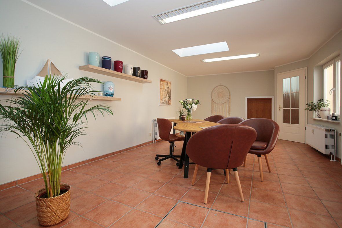 Ein Raum mit einem Tisch und Stühlen und einer Topfpflanze