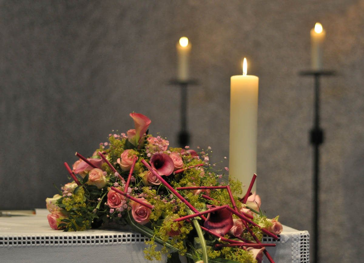 Ein Tisch mit Blumen und Kerzen darauf