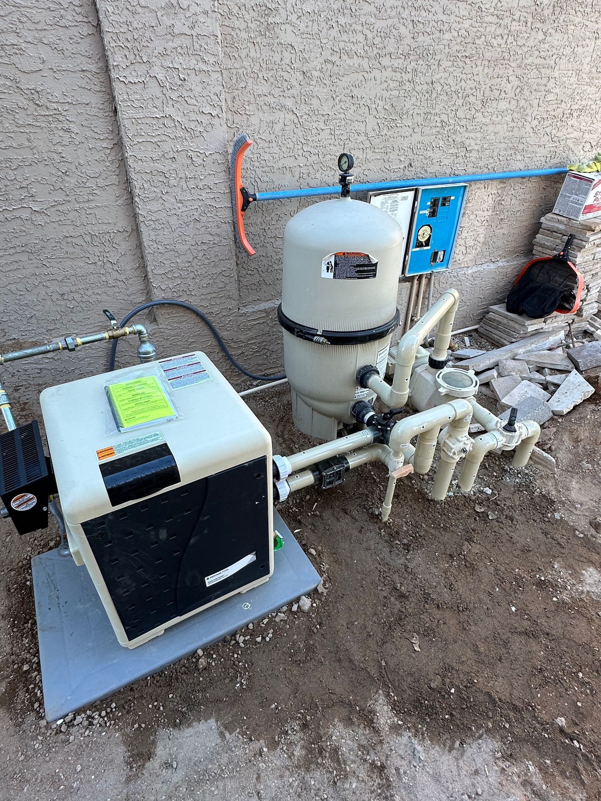 A bunch of swimming pool equipment is laying on the ground.