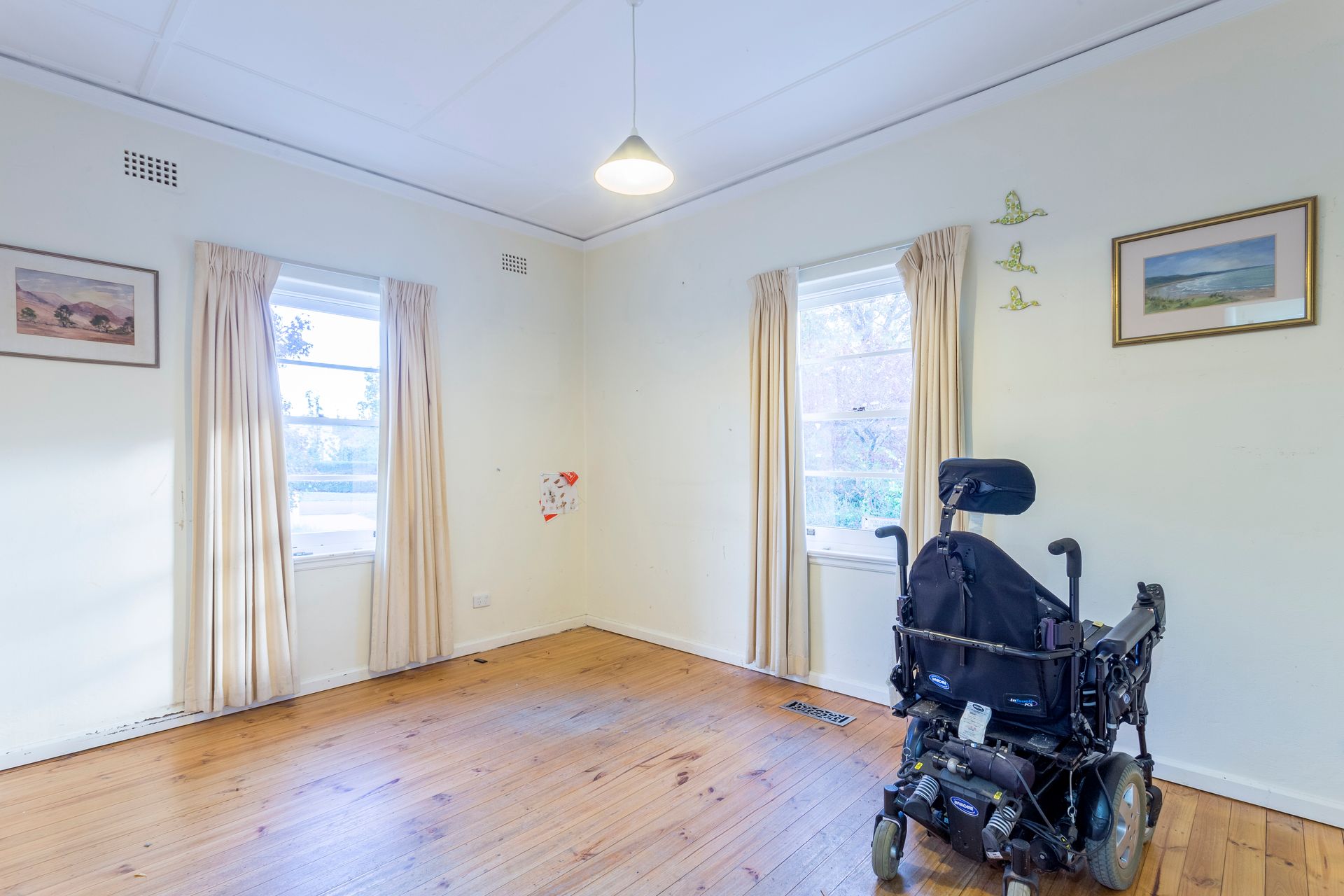 A small outdoor patio with a blue planter, sliding glass door, and a white handrail.