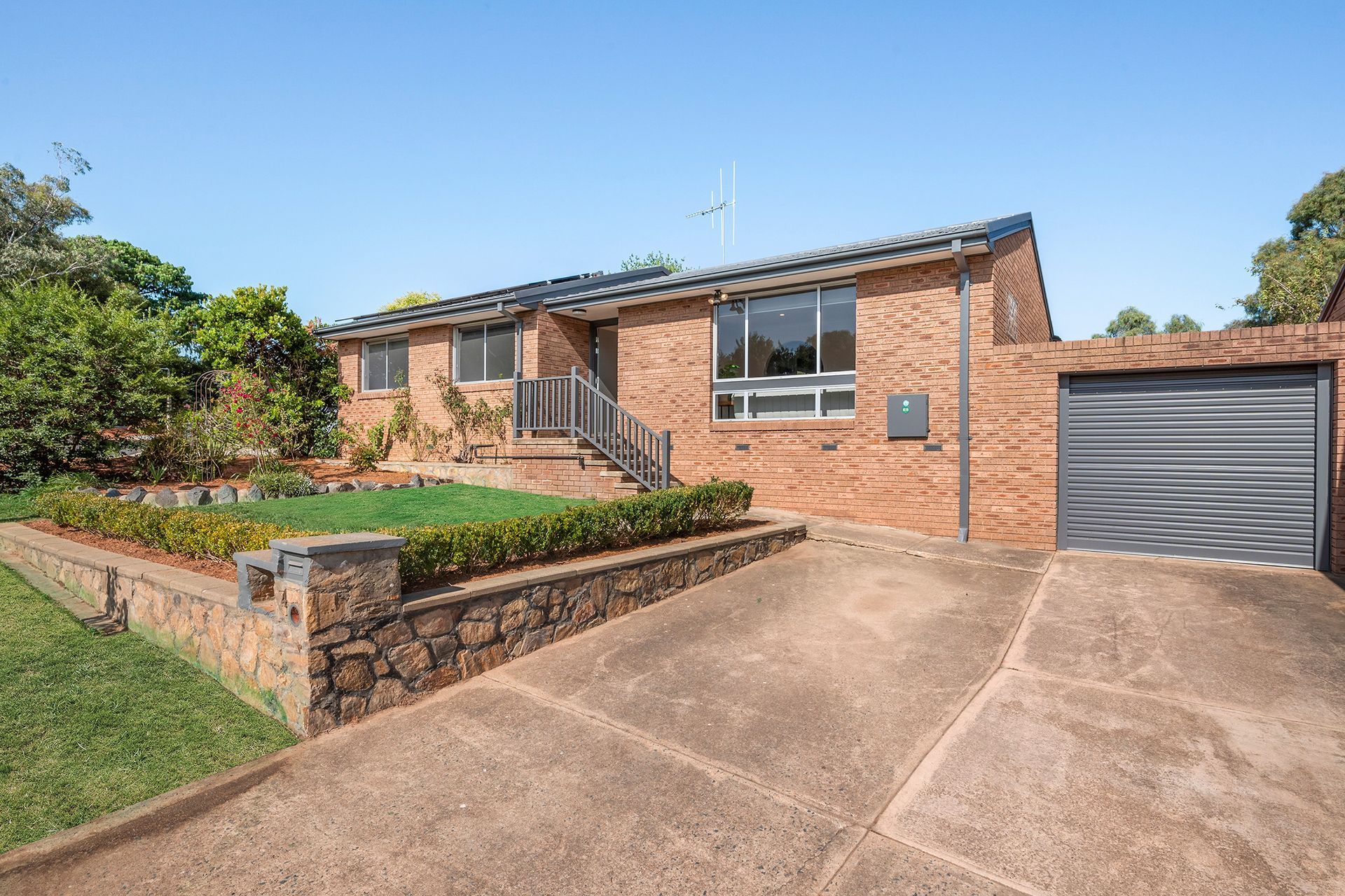 Brick house with a driveway and attached garage on a sunny day.