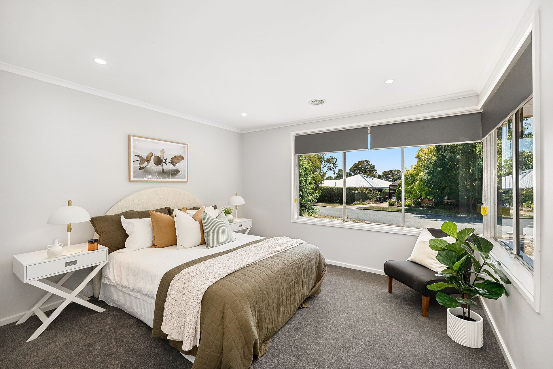 Bedroom with a bed, nightstands, a bench, and a large window with a view.