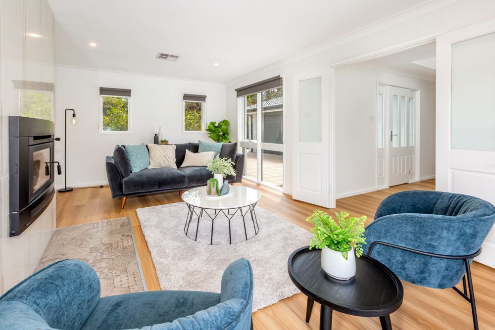 Living room with blue velvet sofa, matching armchairs, and a modern fireplace.