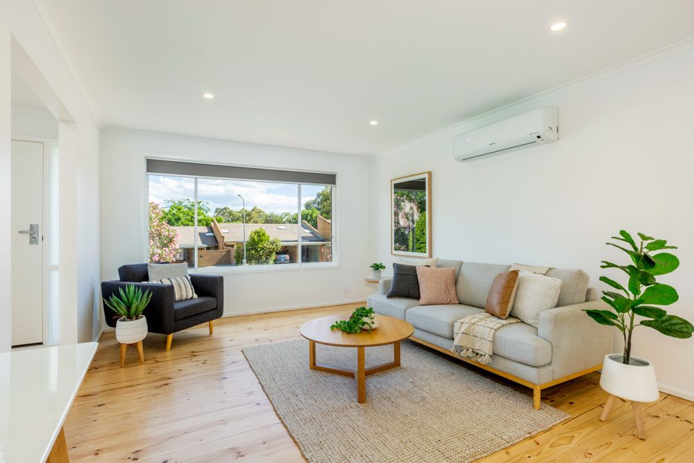 Living room with a gray couch, armchair, wooden coffee table, and large window.