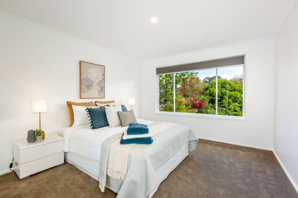 White kitchen and dining area with sliding glass door to backyard. Bright, modern decor.
