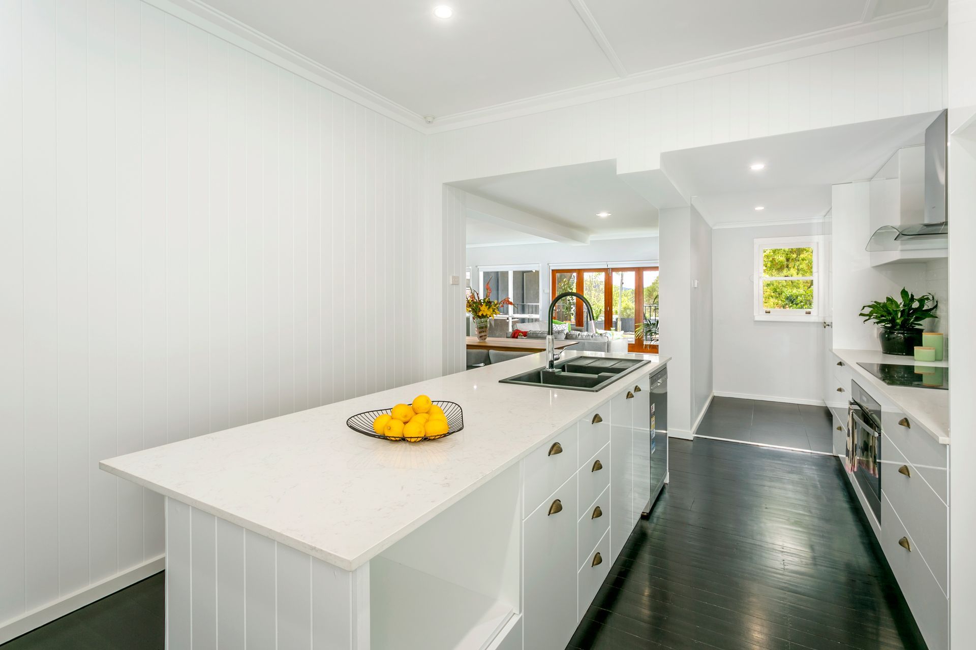 Dining room with wooden table and chairs, French doors to a balcony, artwork on the wall.